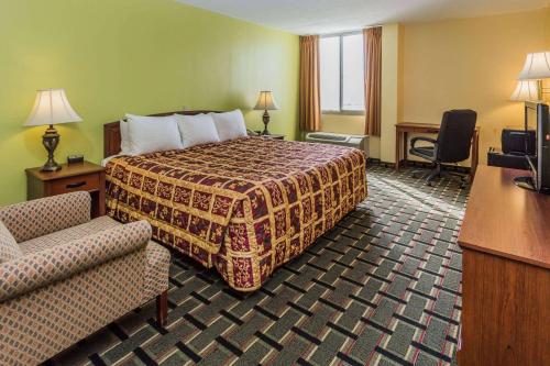 Habitación de hotel con cama y silla en Days Hotel by Wyndham Danville Conference Center, en Danville