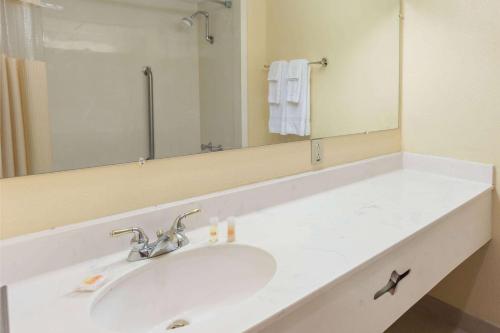 a bathroom with a sink and a mirror at Days Hotel by Wyndham Danville Conference Center in Danville