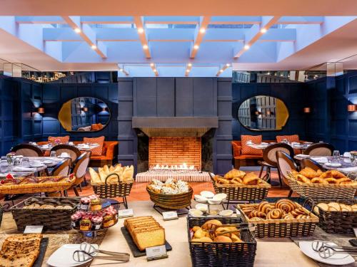 a large room with a fireplace and a table of food at Sofitel Bogota Victoria Regia in Bogotá