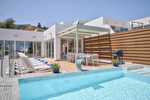 ein Pool vor einem Haus in der Unterkunft Villa Ida - Indoor Heated Pool, Sauna, Games Room and Gym in Mellieħa