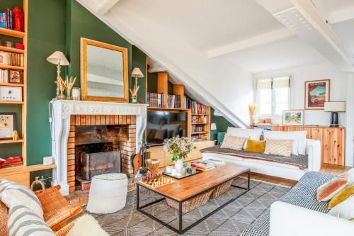 een woonkamer met een open haard en groene muren bij Appartement Borghese - Welkeys in Boulogne-Billancourt