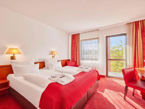 バート・デュルクハイムにあるMercure Hotel Bad Duerkheim An Den Salinenのベッド2台と窓が備わるホテルルームです。