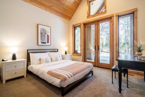 1 dormitorio con 1 cama, escritorio y ventanas en Riverwatch by AvantStay Deschutes in Your Yard, en Bend