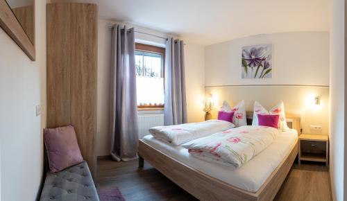 - une chambre avec un lit doté d'oreillers et d'une fenêtre dans l'établissement Haus Sonnengarten-Lienz, à Lienz