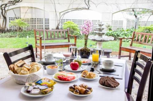 uma mesa com comida de pequeno-almoço numa mesa com cadeiras em You Stay at Vila Olimpia - The World em São Paulo