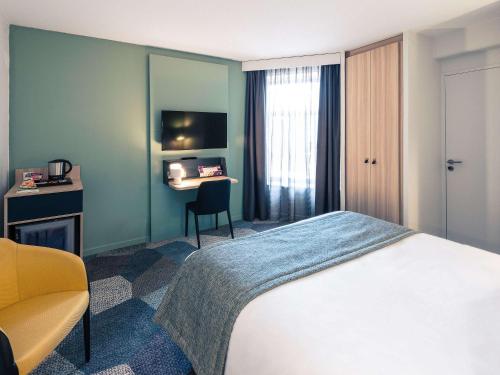 ティオンヴィルにあるHôtel Mercure Thionville Centre Porte du Luxembourgのベッドとデスクが備わるホテルルームです。