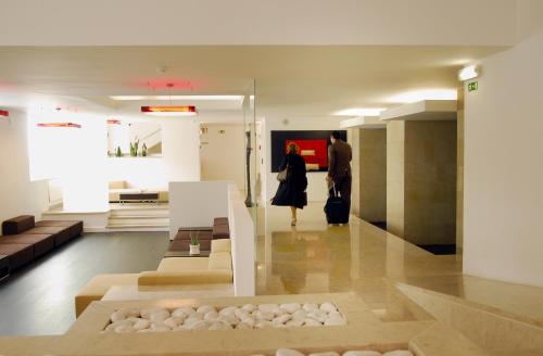 a woman standing in a room with a mannequin at Hotel Jeronimos 8 in Lisbon