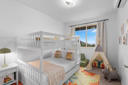 a white bunk bed in a white room with a window at Lealea by AvantStay Ocean Mountain Views in Waianae