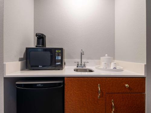 a small kitchen with a microwave and a sink at Hampton Inn Deerfield Beach in Deerfield Beach