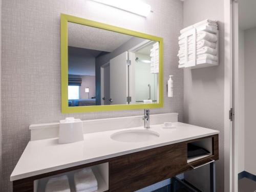a bathroom with a sink with a yellow mirror at Hampton Inn Deerfield Beach in Deerfield Beach