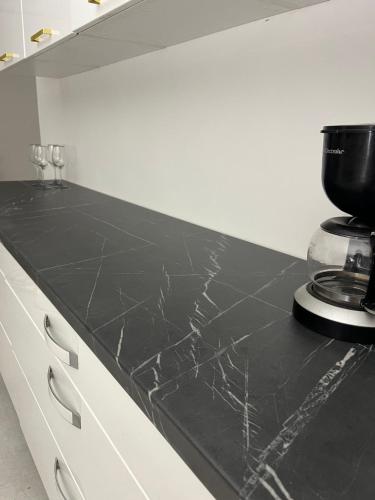 eine schwarze Arbeitsplatte in einer Küche mit einem Gerät in der Unterkunft Atómovy Kryt Košice in Barca