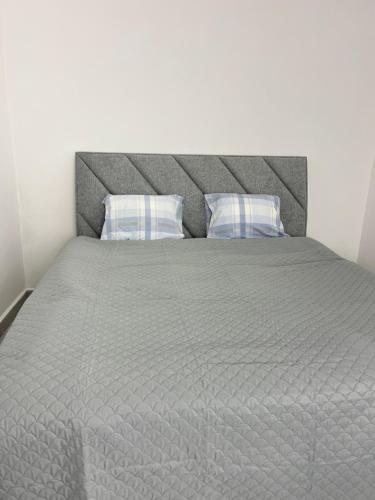 Una cama con dos almohadas encima. en Atómovy Kryt Košice en Barca