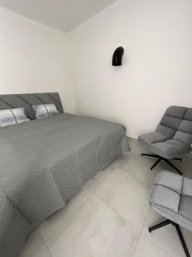 1 dormitorio con 1 cama y 1 silla en Atómovy Kryt Košice en Barca