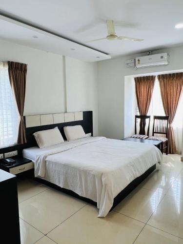 ShravanabelagolaSDK Residency的卧室里有一张铺着白色床单的大床