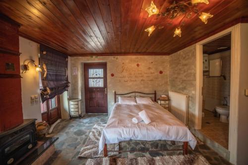 a bedroom with a bed and a wooden ceiling at Ξενώνας Θόλος Βαλτεσινίκο in Valtessiniko 