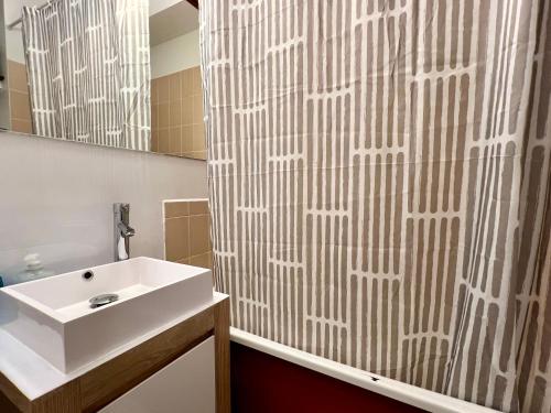 ein Bad mit einem Waschbecken und einem Duschvorhang in der Unterkunft Le Balme Studio WiFi/Parking/Balcony in Chamonix-Mont-Blanc