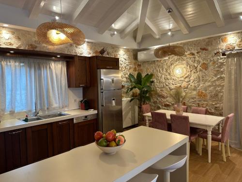 a kitchen with a table with a bowl of fruit on it at Iguana Villa in Kalamaki