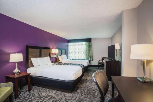 a hotel room with two beds and a table and chairs at La Quinta by Wyndham Clearwater South in Clearwater