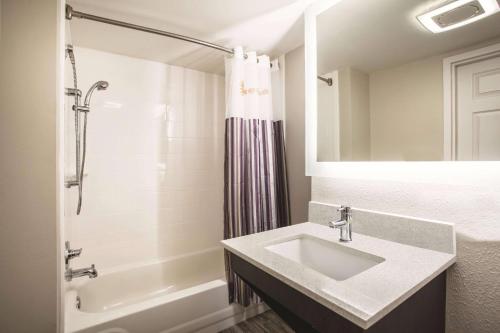 a bathroom with a sink and a shower and a tub at La Quinta by Wyndham Clearwater South in Clearwater