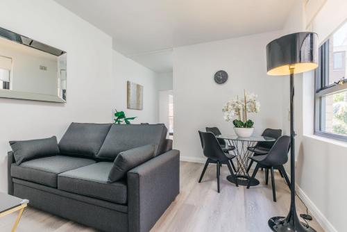 a living room with a couch and a table at Grace at Mosman Apartments in Sydney