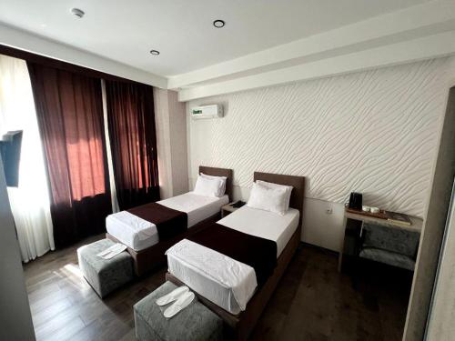 a hotel room with two beds and a couch at Shosh Palace in Tashkent