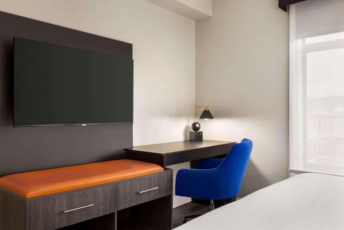 a bedroom with a desk and a blue chair at La Quinta by Wyndham Mt. Laurel - Philadelphia in Mount Laurel