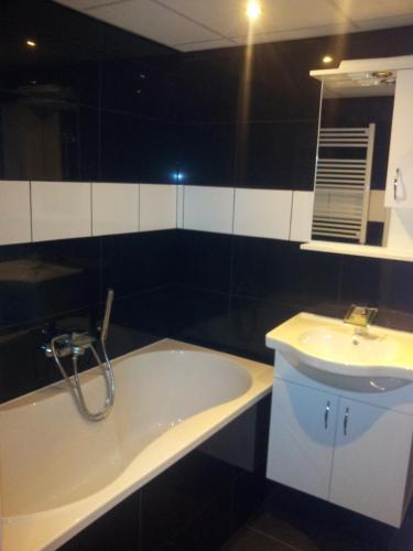 a bathroom with a bath tub and a sink at Bed & Kitchen Den Oever in Den Oever
