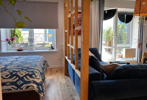 um quarto com um sofá, uma cama e janelas em VIP apart 700 em Tbilisi