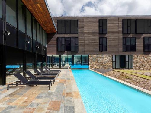 a swimming pool with lounge chairs in front of a building at Peppers Marysville in Marysville