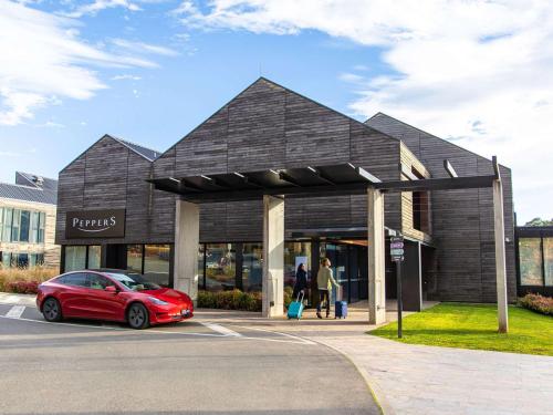 a red car parked in front of a building at Peppers Marysville in Marysville