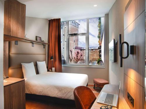 Tempat tidur dalam kamar di Mercure Fribourg Centre Remparts