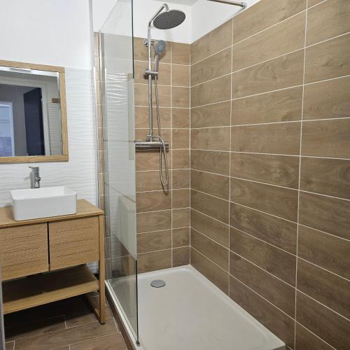 La salle de bains est pourvue d'une douche et d'un lavabo. dans l'établissement Emplacement Idéal : Appartement 2 Chambres en Plein Cœur d'Orange, à Orange