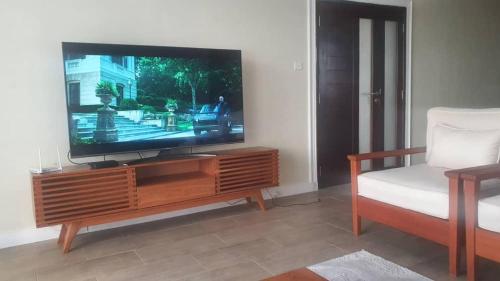 Una televisión o centro de entretenimiento en Kawe Lux Poolside Apartment