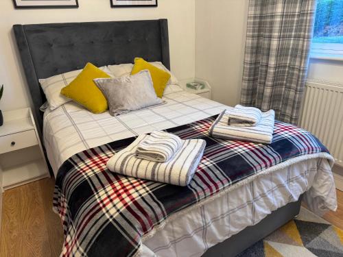 a bed with towels and pillows on top of it at Brick lodge house in Castle Donington