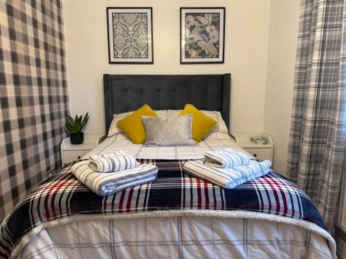 een bed met twee dekens en kussens erop bij Brick lodge house in Castle Donington