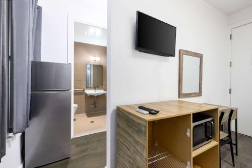 a room with a refrigerator and a desk with a mirror at Hotel 27 by LuxUrban, a Baymont by Wyndham in New York