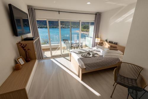 a bedroom with a bed and a view of the ocean at Apartments Holidays Roko in Grebaštica