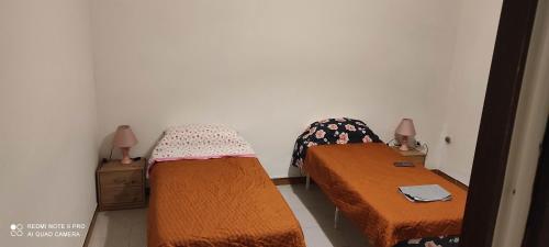 2 camas en una habitación pequeña con 2 lámparas en Margherita, en Seregno