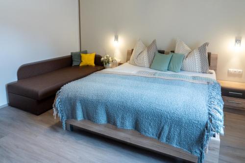 a bedroom with a bed and a couch at Haus Sonnengarten-Lienz in Lienz