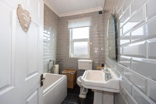 a white bathroom with a sink and a toilet at GuestReady - Ideal Stay in Chorlton in Manchester