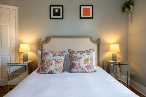 a bedroom with a bed with two lamps and two pillows at GuestReady - Ideal Stay in Chorlton in Manchester