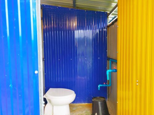 baño con aseo y paredes azules y amarillas en บ้านควนคาเฟ่&โฮมสเตย์ สตูล, 