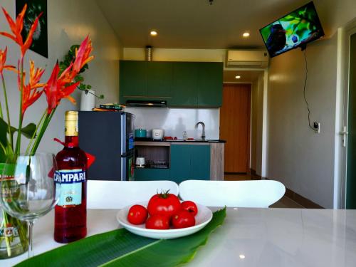 a table with a bowl of tomatoes and a bottle of wine at Mi Amor Luxury Island Apartment - 3 minutes to the beach in Phu Quoc