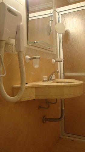 a bathroom with a sink and a phone at Le Soleil Apart Hotel in Colón