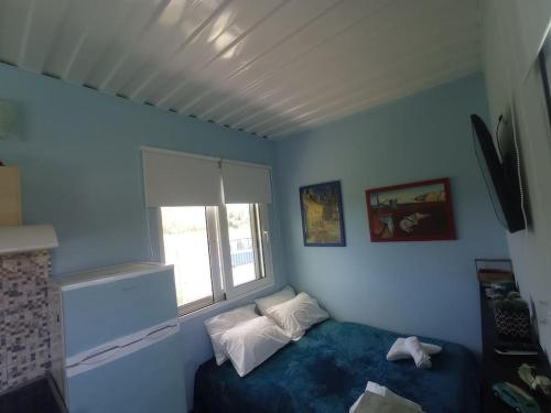 a blue room with a bed and a window at Micro_Ble vacation home in Ropanianá