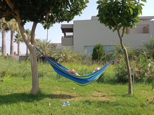 a man laying in a hammock between two trees at Micro_Ble vacation home in Ropanianá