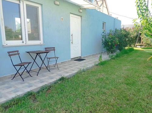 a table and chairs on a patio next to a house at Micro_Ble vacation home in Ropanianá