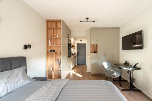 a bedroom with a bed and a desk with a chair at Urban Studios near Iulius Mall in Cluj-Napoca