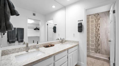 a white bathroom with a sink and a mirror at Sun Or Shade 2 Patios Enclosed Private Back Yard in Scottsdale