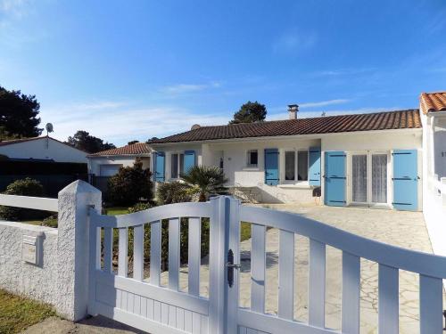 une clôture blanche devant une maison dans l'établissement La Palmyre - RAVISSANTE MAISON MITOYENNE - proximite CENTRE-VILLE, aux Mathes